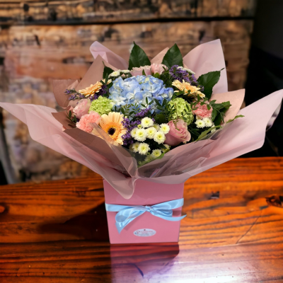 Pretty and Perfect Pastel - Stunning pastel blooms with lush greenery arranged in a aqua handtied