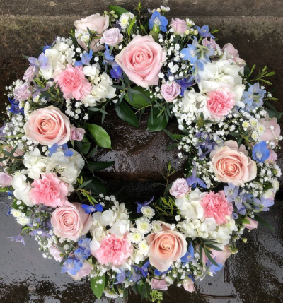 Mixed floral Wreath - Blush roses, hydrangea, delphiniums, carnations, gyp and greenery. It is arranged on a wet floral foam frame. Easy to carry. Different colours can be requested in the notes. Perfect for a funeral tribute, memorial or grave.